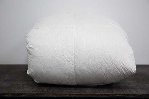 A Pillowtex Classic Weight Feather and Down Comforter resting on a wooden table.