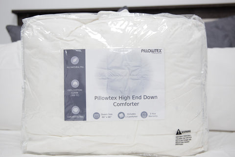 A bed with a Pillowtex High End Down Comforter on top, providing maximum comfort.