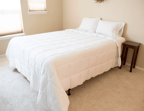 A white Pillowtex Hotel Blanket on a bed.
