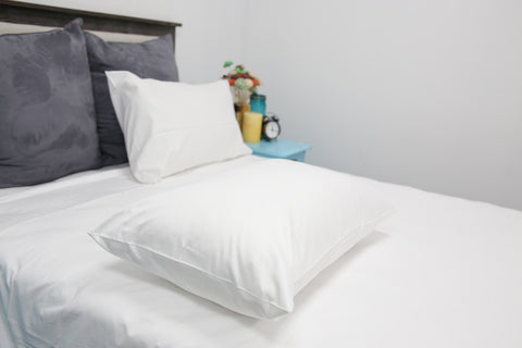 A white bed with two Pillowtex Hotel Sheet Set pillows, made from 300 thread count cotton & polyester blend fabric, resembling a Hotel Sheet Set.