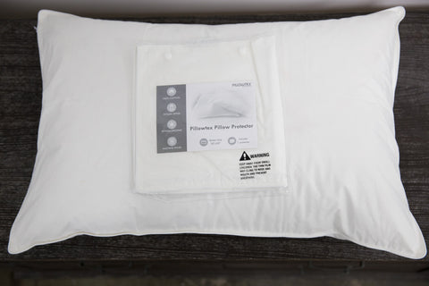 A white Pillowtex Cotton Pillow Protector with a Pillowtex label attached to it.