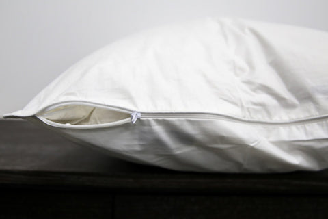 A Pillowtex Cotton Pillow Protector with a rust-resistant zipper.