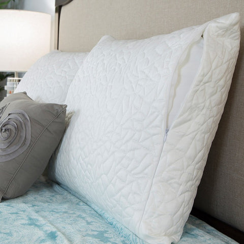 A white pillow resting on a bed with a Protect-A-Bed Snow Pillow Protector.