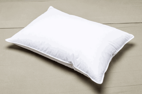 A Registry Down Alternative Polyester Pillow on a beige bed provides soft support.