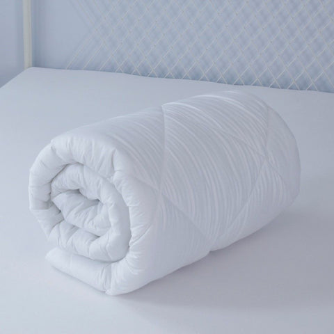 A white comforter on top of a Down Etc. Lily-Pad Waterproof Mattress Pad.
