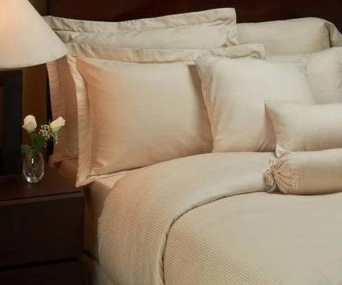 A Martex Magnificence Duvet Cover | Tan with pillows and a 1888 Mills lamp.
