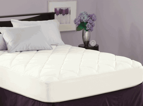 An image of a Spring Air Stain Protection Mattress Pad on a bed by Pacific Coast Feather Company.