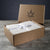 A brown cardboard gift box with Delilah Home’s logo sits open on a wooden surface. Inside are neatly folded and ribbon-tied Final Sale: Organic Hemp Bed Sheet Collection sheets. The background is dark gray.
