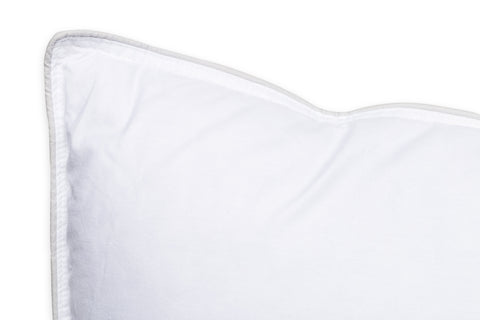 A close-up view of a neatly stitched, clean white Downlite White Goose Feather Pillow corner against a white background, emphasizing simplicity and hygiene in bedding.