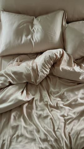 A bed with a Pillowtex Copper Infused Bamboo Duvet Cover and pillows, infused with copper for antibacterial benefits.