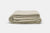 The American Blossom Linens Herringbone Weave Blanket, crafted from organic cotton in the USA, is displayed neatly folded on a white background, highlighting its super soft texture and cozy, heirloom-quality weave.