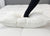 A hand presses into the JS Fiber "Ultra Down" Polyester Pillow | Firm on a quilted white mattress, making a deep indentation. A gray headboard in the background highlights the machine-washable JS Fiber pillow’s firm support and softness.
