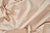 A close-up of American Blossom Linens’ Colored Cotton Bed Pillowcases—crafted from natural, unbleached heirloom cotton—shows their soft drape, gentle wrinkles, and textured weave with subtle dark flecks. Proudly American made.
