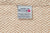 The Herringbone Weave Blanket by American Blossom Linens is made in the USA from 100% organic cotton. This beige and cream heirloom features a pink blossom tag and showcases impeccable craftsmanship.