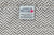 The Herringbone Weave Blanket from American Blossom Linens, made from 100% USA organic cotton, features a sewn label and pink blossom icon, showcasing heirloom quality and expert American craftsmanship.