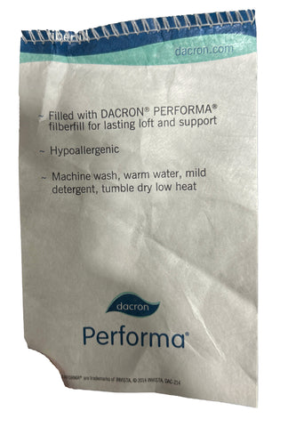 A crumpled care label showing washing instructions for a JS Fiber Hollofil II pillow; highlights hypoallergenic qualities, machine washability, and low heat tumble drying.
