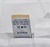 A white tag with a yellow edge on the Envirosleep Platinum Garneted Polyester Fiber Fill Pillow by Manchester Mills gives eco-friendly care instructions. "PLATINUM" and manchestermills.com emphasize its sustainable comfort. Machine wash cold, gentle cycle.
