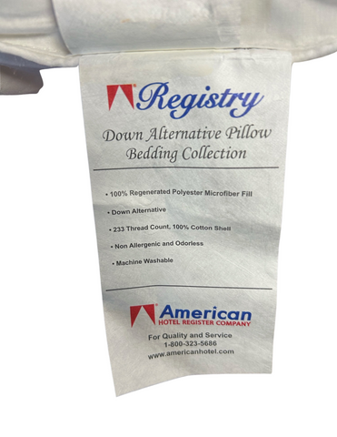 A close-up of a white "Registry® Down Alternative Polyester Pillow | Soft" label detailing product features such as 100% regenerated polyester fill, 233 thread count, cotton shell, hypoallergenic, odor.