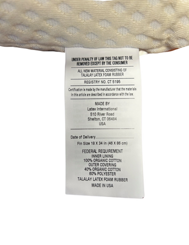 A close-up of a white Latex International Rejuvenite Natural High Profile Pillow law label listing the manufacturer's information, registration number, and materials such as 100% inner lining of cotton, 40% bamboo fiber, 60% organic.