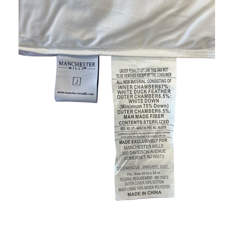 Close-up of a clothing label from "Temperloft ReNew Pillow Down/Down Alt Fill | Environmentally Friendly" by Manchester Mills showing material composition and care instructions in English, stitched on an environmentally friendly white textile background.
