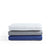 The Weekender Double-Brushed Microfiber Sheet Set from Malouf is showcased in a stack of three folded sheets against a white background. This luxurious set includes a wrinkle-resistant white top sheet, gray middle sheet, and blue bottom sheet. Each piece features double-brushed microfiber with neatly tailored edges, highlighting the smooth, wrinkle-free fabric.