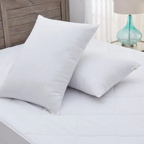 Two Woodspring Ecoendure Pillows from Keeco on top of a luxurious hotel bed featured at many Choice® Hotels.