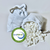 Two drawstring bags with a white and blue pattern sit on a white surface, one spilling out small foam cubes—perfect for customizing your Ergonomic & Adjustable Body Pillow for Side Sleepers from The Clutcher Pillow. A CertiPUR-US logo appears in front.