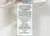 The Down Etc. 50% White Goose Down / 50% White Goose Feather Pillow has a white fabric tag listing its fill (50/50 down/feathers), 100% cotton cover, care info, legal warnings, barcode, and UPC. Made by Down Etc. in Millbrae, CA.