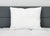 A Pillow Factory Comforel Pillow, featured at Sheraton Hotels, rests on a white quilted mattress against a dark grey headboard.