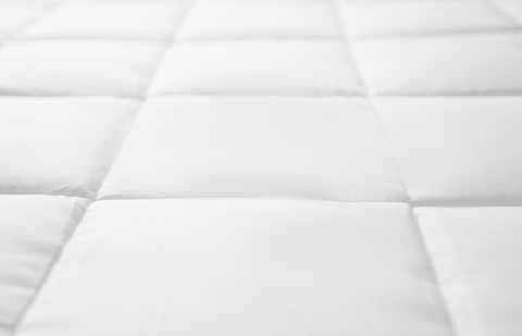 A close up of a Pillowtex Hotel Blanket | Soft Fabric & Silky Smooth Fill, a hypoallergenic white quilted mattress by PIllowtex.
