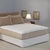 A bed with a Restful Nights Waterbed Mattress Pad, topped with a polyester mattress pad.