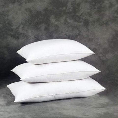 Three stacked JS Fiber Gold Choice Polyester Pillows with hollow siliconized fiberfill against a textured grey background, suggesting a minimalist and comfortable bedroom accessory aesthetic.