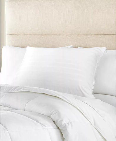 A pristine white Stearns & Foster Down Halo Pillow™ | 600 Fill Power and duvet set on a neatly made bed with an upholstered beige headboard, evoking a sense of calm and cleanliness in a contemporary bedroom setting. The medium pillow density ensures