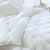 A white Restful Nights Ultima Supreme Synthetic Fill Comforter | Middle Weight on a bed in a bedroom.