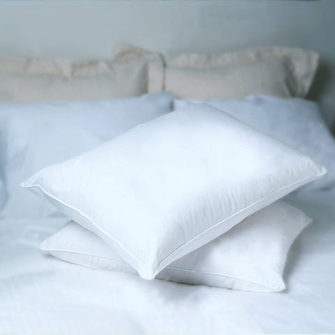 Two Pacific Coast Feather Colossus Polyester Pillows providing support and comfort on a white bed.