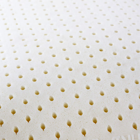 A close-up view of a Natural Latex Pillow by I AM™ mattress topper with conical protrusions designed to enhance comfort and airflow, characteristic of 'egg crate' style foam.