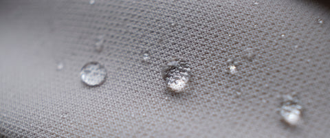 A close up of water droplets on a Pillowtex Waterproof Pillow Protector.