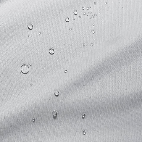 A close up of water droplets on a white fabric, possibly from a PureCare ReversaTemp 5-Sided Mattress Protector.