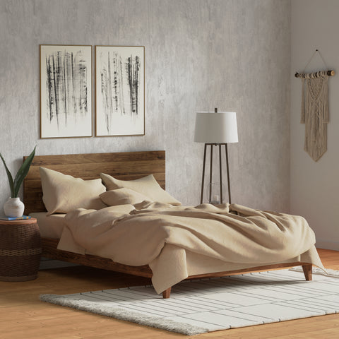 A serene bedroom featuring a wooden bed with beige 300-count Delilah Home Organic Cotton Duvet Cover, complemented by abstract wall art, a sleek floor lamp, and bohemian decor accents, nestled in a warm, minimalist.