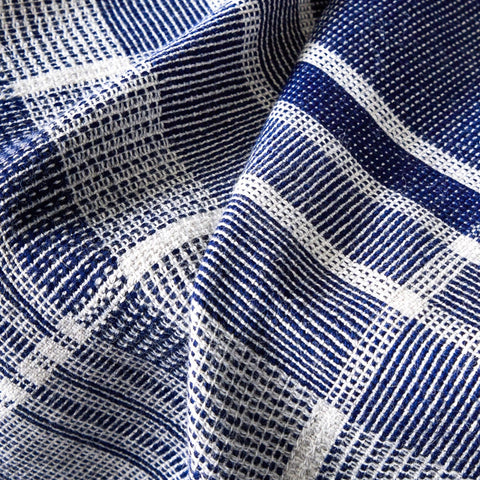 A close-up of a Fairkind Escalante Alpaca Throw in blue and white checkered design.