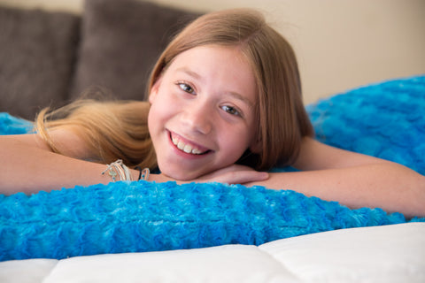 A young girl laying on top of a Pillowtex Body Pillow Cover in Colorful Plush Faux Fur.