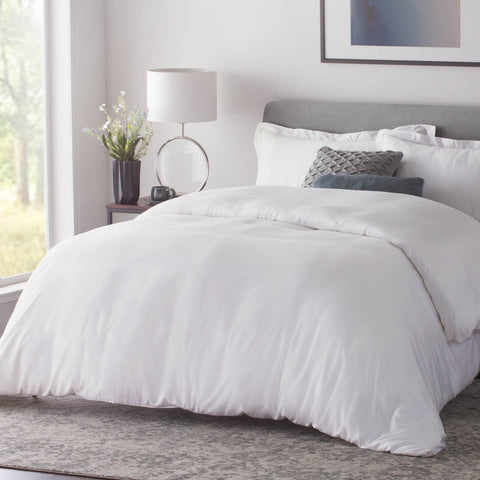 A Malouf Bamboo Duvet Set in a bedroom with a window, perfect for anyone looking for hypoallergenic bedding.