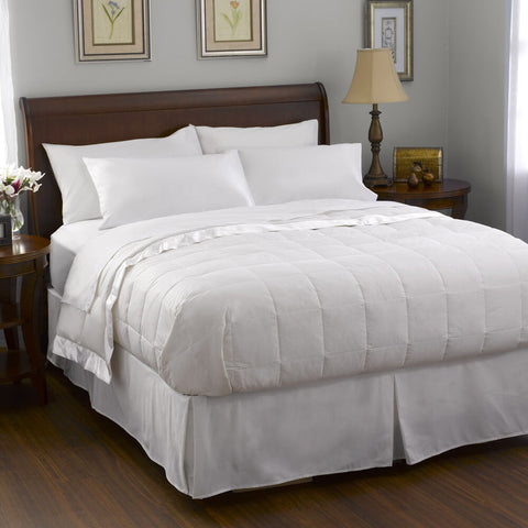 A white Pacific Coast Feather Company comforter on a bed in a bedroom, similar to those seen in Marriott Hotels.
