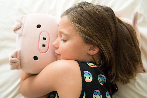 A little girl peacefully sleeping with a Memory Foam Pig Themed Pillow, a perfect children's gift from Pillowtex named Wilbur The Pig.