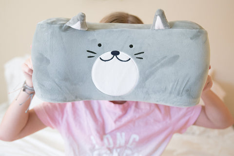 A girl snuggling a Memory Foam Cat Pillow with Tommy The Cat face on it, perfect for children's gifts from Pillowtex.