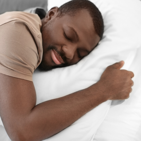 A black man sleeping on a Pillow Factory Housekeeper's Choice Heavenly Spiral Pillow- Featured at Many Borgata Hotel Casino & Spa®.