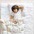 A young boy peacefully sleeps with a white blanket and a Pillowtex Adjustable Loft Pillow - Three Pillows In One - Perfect For All Sleeping Positions.