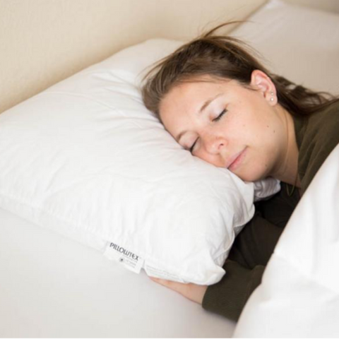 A woman sleeping on a Pillowtex Down Alternative Medium Firm Pillow.