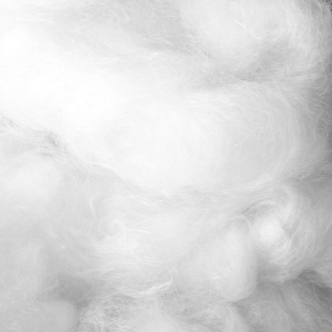 A close up of a pile of white cotton, resembling a Malouf Gelled Microfiber Pillow stuffed with Gelled Microfiber.