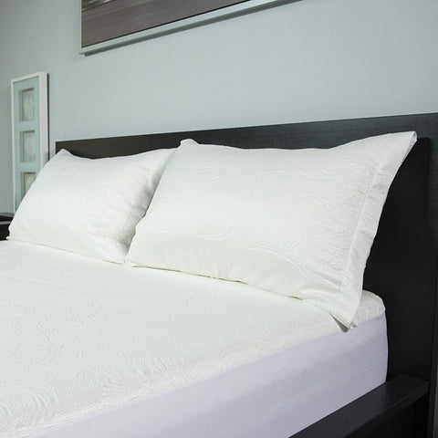 A white bed with Protect-A-Bed Crystal Cooling Pillow Protectors With Tencel sheets and pillows.